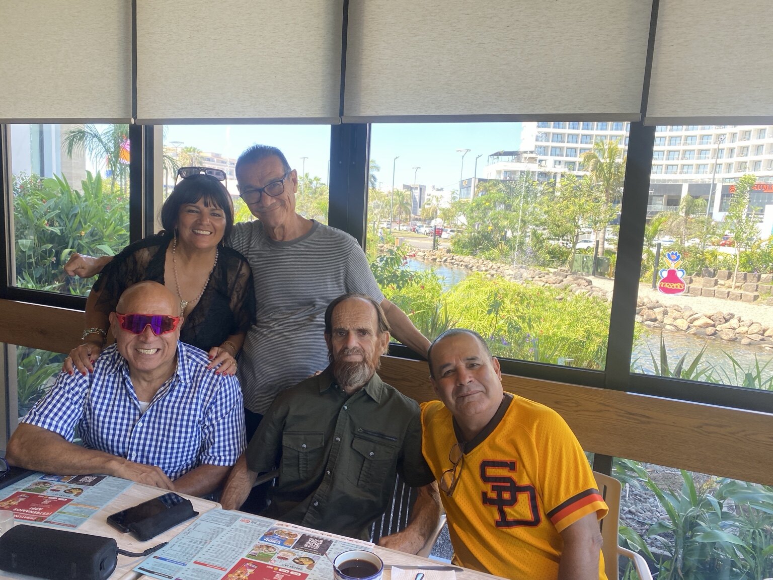 Cinco amigos reunidos junto a una ventana en 2026